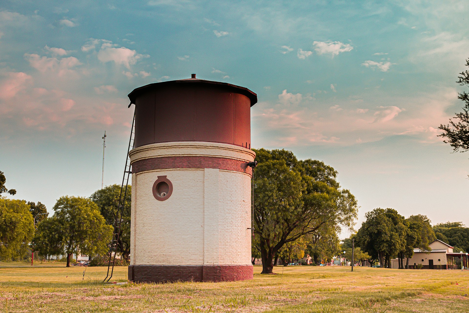 red and white concrete building near green trees under white clouds and blue sky during daytime